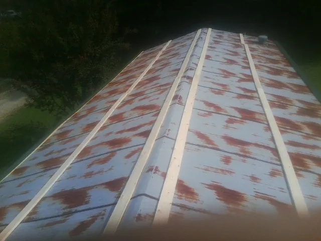 Rusted metal roof panels with new wood purlins before replacement — Storm Damage Roof Repair in Hunker by Roofing Brothers