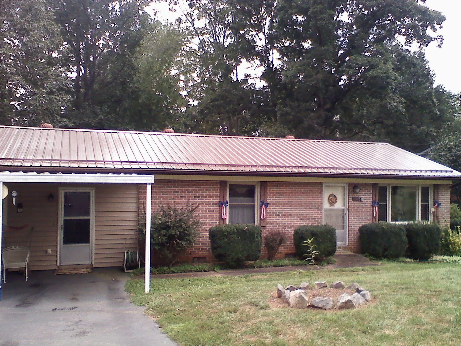 Bronze metal roof and carport on a brick ranch home — Roof Repair work by our crew in Hunker